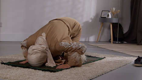 Muslimische-Frau-Mit-Hijab-Zu-Hause-Beten-Kniend-Auf-Gebetsmatte-7